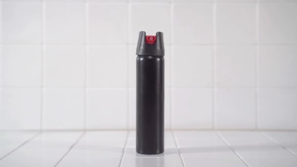 Schwarze Pfefferspray-Dose auf weißem Hintergrund in Nahaufnahme — Stockvideo