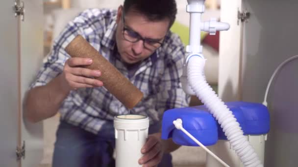 Hombre inspecciona el elemento filtrante de un filtro de agua casero — Vídeos de Stock