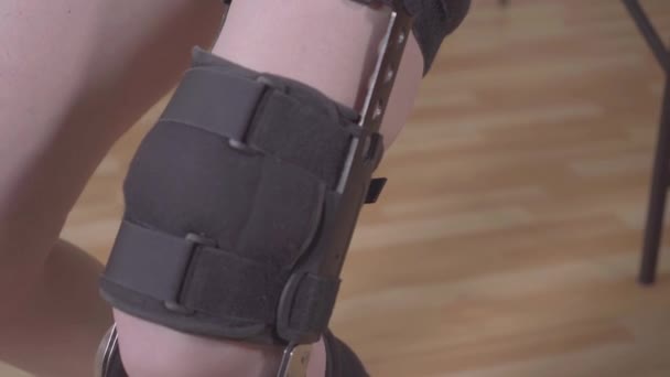 Pierna femenina con ortesis rodillera después de una lesión — Vídeo de stock