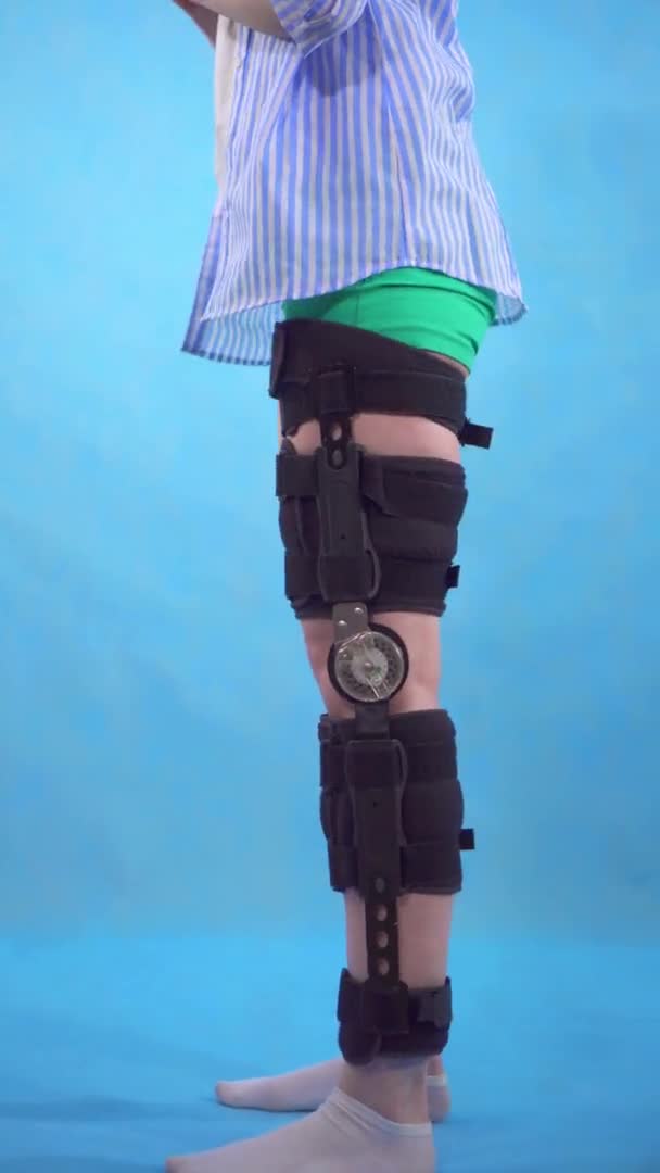 Vídeo vertical de una mujer joven en cuclillas después de una lesión rodilla doblar ortesis rodillera — Vídeo de stock