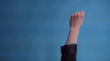 female hand shows thumbs up on blue background vertical video