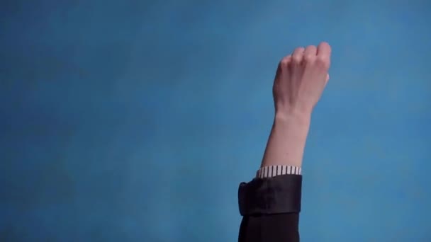 Mão feminina mostra polegares para cima no fundo azul vídeo vertical — Vídeo de Stock