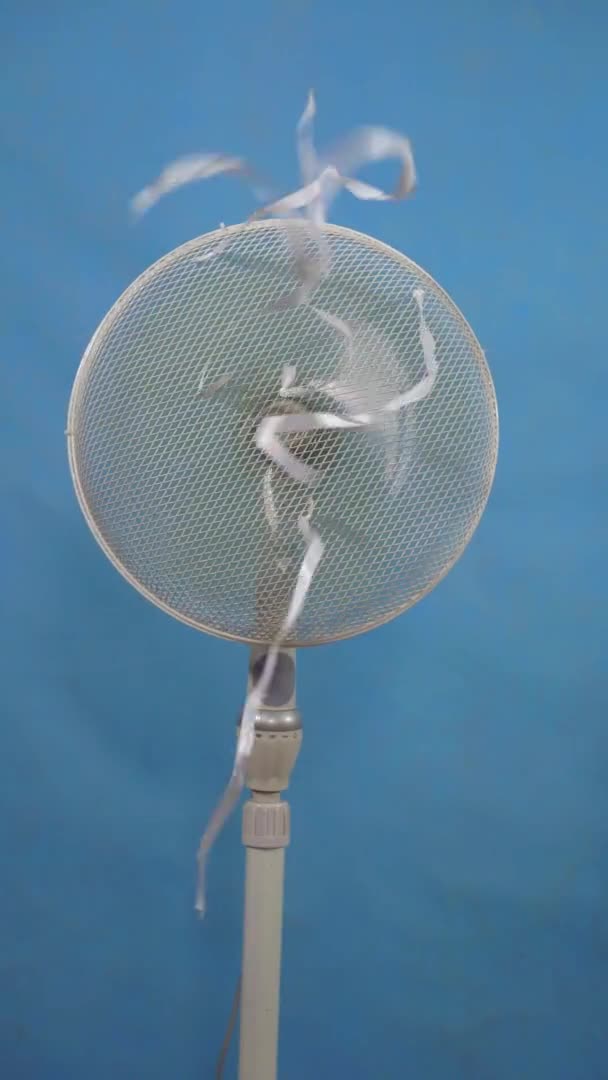 A working white fan for cooling heat problem on blue background vertical video — Stock Video