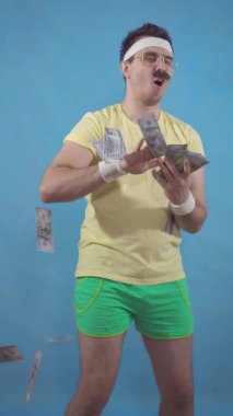 Funny mustachioed man from the 80s throws paper money standing on a blue background vertical video