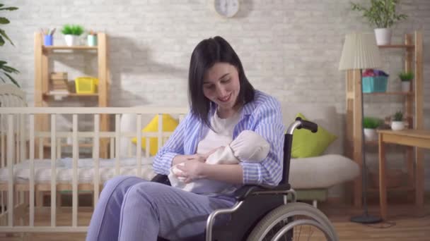 Portret van een jonge gehandicapte vrouw en een pasgeborene die naar de camera kijkt en glimlacht — Stockvideo