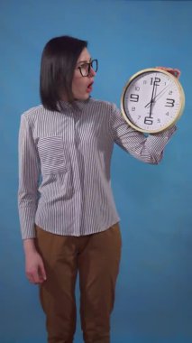 young pretty woman shocked with office hours in the hands of the deadline