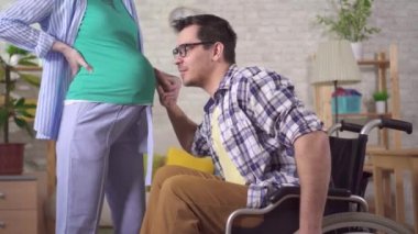 Tekerlekli sandalyedeki engelli bir adam ve gelecekteki hamile karısı.