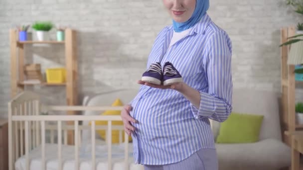 Femme musulmane enceinte dans un hijab regardant la caméra — Video