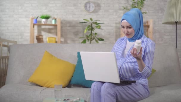 A Muslim young pregnant woman searches the Internet for information about medicine — Stock Video