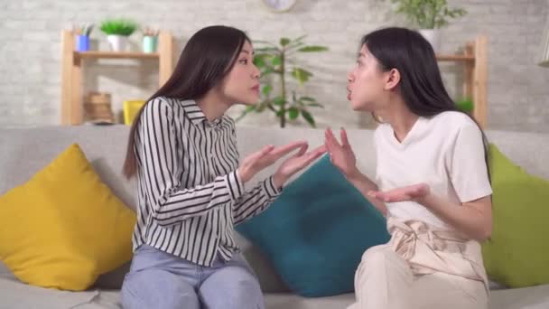 İki genç Asyalı kadın kavga ediyor ve birbirlerine kızgınlar. Oturma odasında oturuyorlar. — Stok video