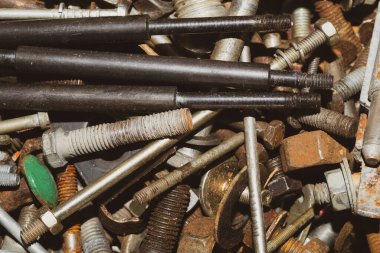 Bağlayıcı ve vidalar yığını yaklaşıyor. Hurda metal. farklı metal parçaları. sanayi arkaplanı