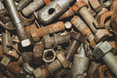 Paslı cıvatalar ve farklı boyutlarda fındıklar. Hurda metal. sanayi arkaplanı