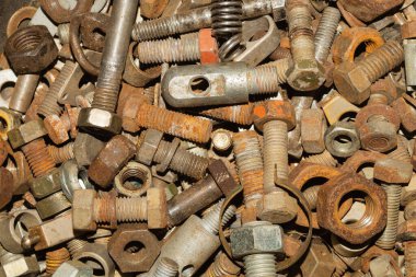 Paslı cıvatalar ve farklı boyutlarda fındıklar. Hurda metal. sanayi arkaplanı