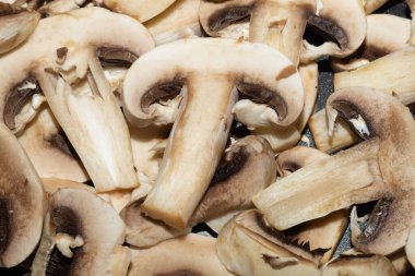 Dilimlenmiş mantar. Arka planda şampiyonlar. Sağlıklı yemek. Vejetaryen beslenmesi. yemek pişirme süreci