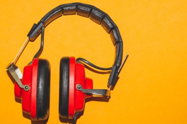Sarı arka planda klasik kırmızı kulaklıklar. Retro kulaklıklar