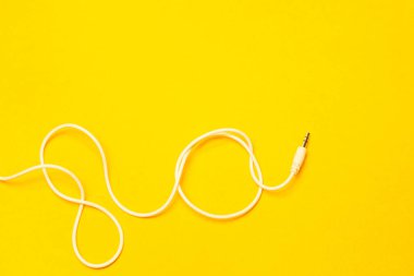 Sarı arkaplanda izole edilmiş beyaz kabloya sahip ses oynatıcısı