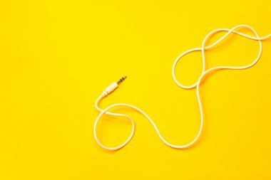 Sarı arkaplanda izole edilmiş beyaz kabloya sahip ses oynatıcısı