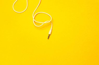 Sarı arkaplanda izole edilmiş beyaz kabloya sahip ses oynatıcısı