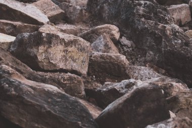 Arkaplanda taş yığını var. Bir yığın kaya. Yıkılmış binaların kalıntıları