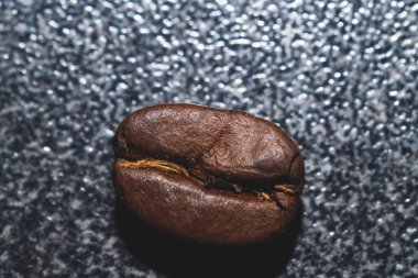 Bir kahve çekirdeği masada yatıyor.