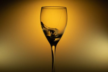 Parlak arka planda su camlara sıçrar. Şarap bardağına su sıçratıyorum. şeffaf kokteyl