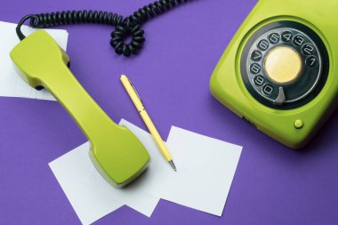 Cep telefonlu klasik bir telefon. Üzerinde bir not olan kalem. Ofis geçmişi. Telefon ahizesi olan klasik yeşil bir telefon. Eski iletişim teknolojisi. Boşluğu kopyala