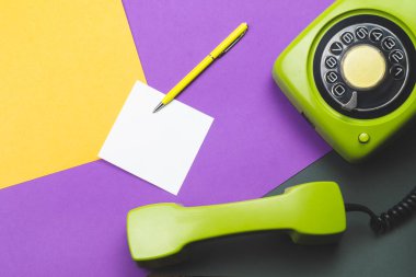 Cep telefonlu klasik bir telefon. Üzerinde bir not olan kalem. Ofis geçmişi. Telefon ahizesi olan klasik yeşil bir telefon. Eski iletişim teknolojisi. Boşluğu kopyala