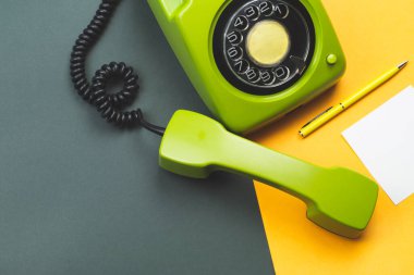 Cep telefonlu klasik bir telefon. Üzerinde bir not olan kalem. Ofis geçmişi. Telefon ahizesi olan klasik yeşil bir telefon. Eski iletişim teknolojisi. Boşluğu kopyala