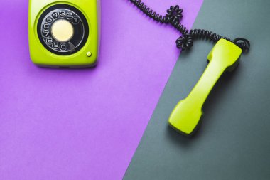 Cep telefonlu klasik bir telefon. Renk arkaplanında telefon alıcısı olan klasik yeşil bir telefon. Eski iletişim teknolojisi. Boşluğu kopyala