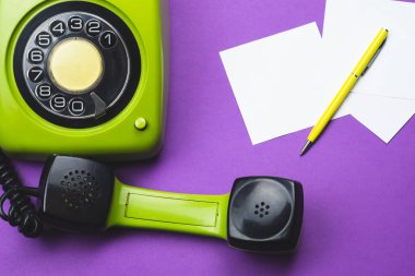Cep telefonlu klasik bir telefon. Üzerinde bir not olan kalem. Ofis geçmişi. Telefon ahizesi olan klasik yeşil bir telefon. Eski iletişim teknolojisi. Boşluğu kopyala