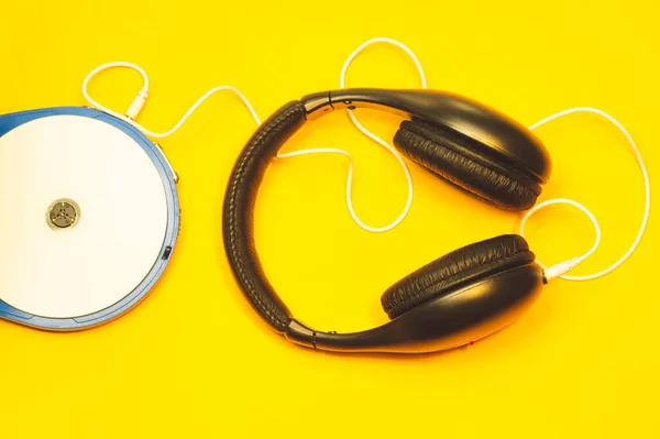 Czarne Słuchawki Białym Kablem Żółtym Tle Odtwarzacz Płyt Kompaktowych Białą — Zdjęcie stockowe