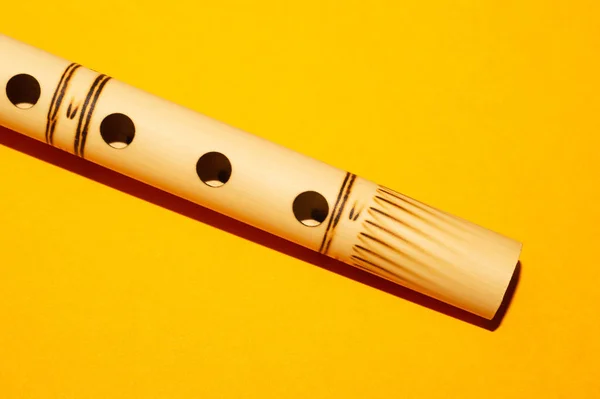 Bamboo flute. simple wind instrument. bansuri flute on yellow background