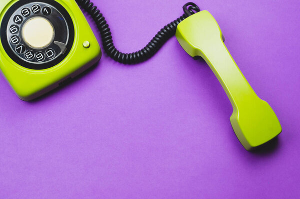 Classic phone with handset. vintage green telephone with phone receiver isolated on purple background. old communication technology. copy space