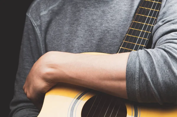 Man holds acoustic guitar. string instrument