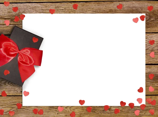 Gift box with red bow ribbon and paper heart on wooden background for Valentines day — Stock Photo, Image