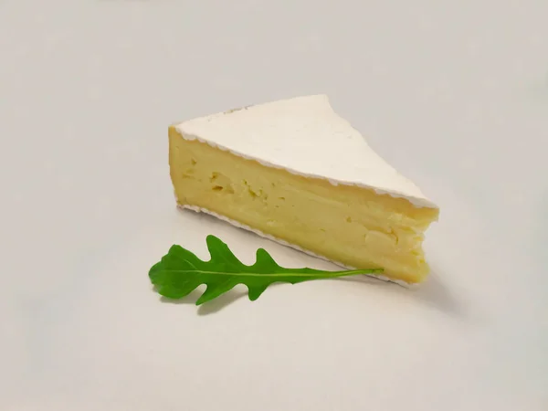 Brie typ av ost. Färsk Brie ost och med gröna blad rucola. — Stockfoto