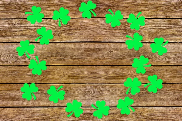 Feuilles de trèfle de papier sur le vieux fond en bois. Symbole des fêtes de la Saint Patrick. Espace pour le texte, vue du dessus — Photo