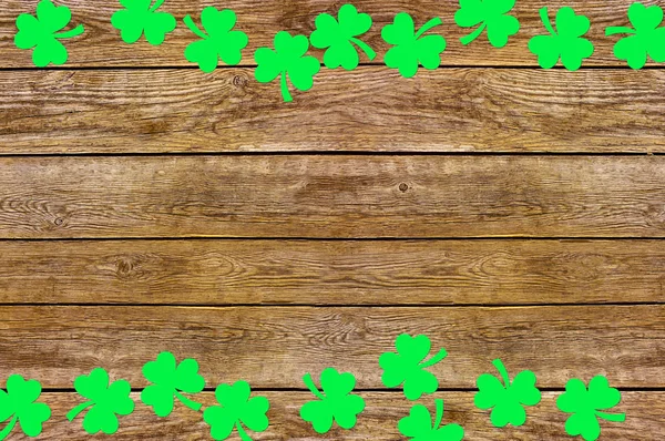 Feuilles de trèfle de papier sur le vieux fond en bois. Symbole des fêtes de la Saint Patrick. Espace pour le texte, vue du dessus — Photo