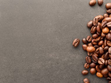 Kırmızı kahve çekirdekleri ve kavrulmuş kahve çekirdekleri siyah arka planda izole edilmiş..