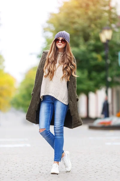 Schöne junge Frau in grüner Strickjacke mit Kapuze, die im herbstlichen Park spaziert. Herbstfasnet-Konzept. — Stockfoto