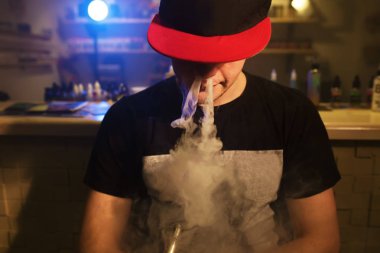 Bir mod tutarak Vaping adam. Vape dükkanında Buhar bulutu.
