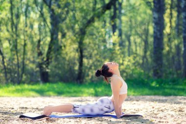 Genç kadın yaz Şehir Parkı yoga egzersizleri yapıyor. Sağlık yaşam tarzı kavramı.