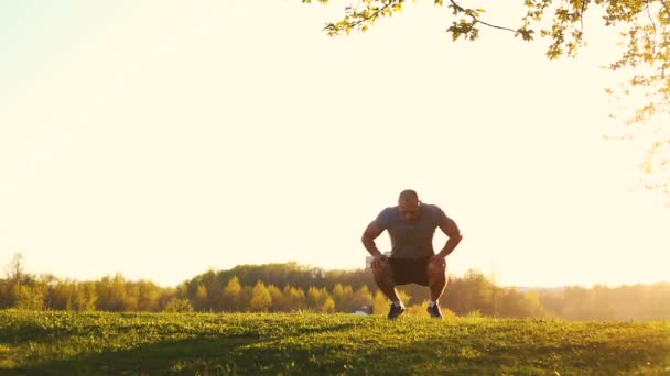 Giovane atleta corridore facendo esercizio di stretching, preparandosi per l'allenamento nel parco. tramonto, video tonica — Video Stock