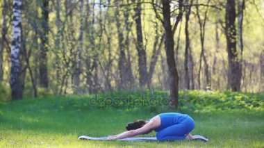 Genç kadın yaz Şehir Parkı yoga egzersizleri yapıyor. Sağlık yaşam tarzı kavramı.