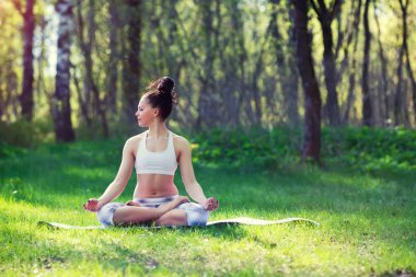 Genç kadın yaz Şehir Parkı yoga egzersizleri yapıyor. Sağlık yaşam tarzı kavramı.