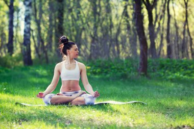 Genç kadın yaz Şehir Parkı yoga egzersizleri yapıyor. Sağlık yaşam tarzı kavramı.