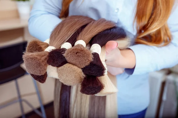 Frau hält Haarverlängerung Ausrüstung aus Naturhaar. Haarproben in verschiedenen Farben — Stockfoto