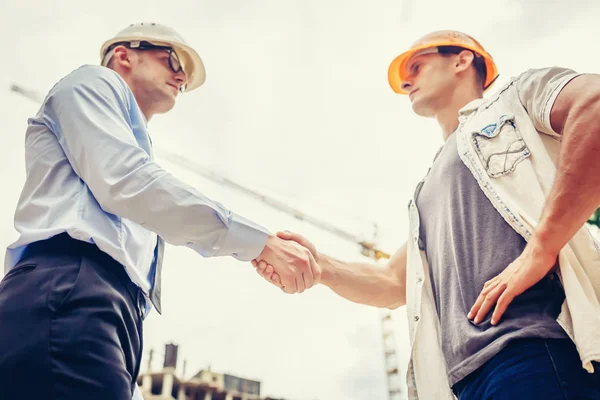 Architecte ingénieur serrant la main de l'autre main sur le chantier de construction. Travail d'équipe, coopération, succès concept de collaboration — Photo