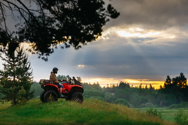 Hombre en el ATV Quad Bike corriendo al atardecer —  Fotos de Stock