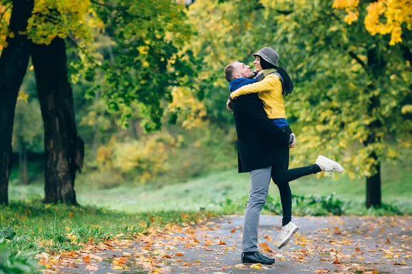 Casal feliz se divertindo em Autumn Park. Árvores amarelas e folhas. Laughing Man and Woman ao ar livre. Conceito de liberdade . — Fotografia de Stock